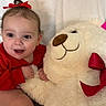 Ashly is registered to the contest to win money with this photo: baby, big_eyes, blanket, brown_nose, child, cute, hand, happy, hugging, indoor, infant, plush_toy, portrait, red_bow, red_clothing, smile, soft_texture, stuffed_animal, teddy_bear, toddler