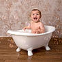Freya is registered to the contest to win money with this photo: baby, bathtub, bubbles, child, clawfoot_tub, floor, happy, indoor, joyful, laughing, naked, person, playful, portrait, room, splash, studio, toddler, wallpaper, wood_floor