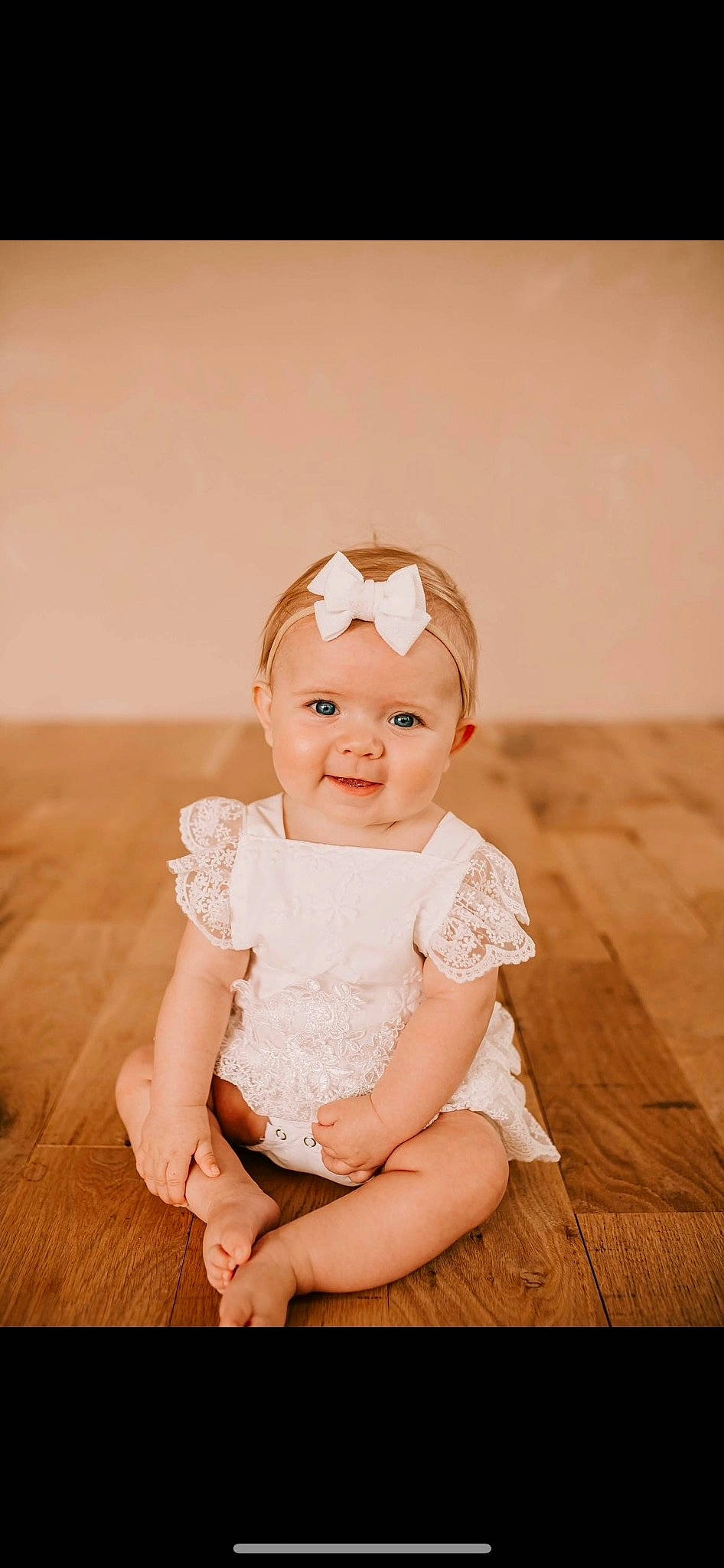 Caroline is registered to the contest to win money with this photo: baby, baby_toddler_clothing, cheek, child, dress, embellishment, flash_photography, flooring, fun, grass, happy, hardwood, headband, headpiece, headwear, person, sitting, skin, sleeve, smile