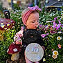 10_months, baby, barefoot, child, cute, denim_overalls, flowers, garden, greenery, headband, infant, milestone_sign, mushroom_statue, nature, outdoor, pink, plants, portrait, sitting, sunlight
