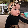 baby, infant, headband, leopard_print, black_clothing, sitting, carpet, living_room, blue_eyes, cute, child, toddler, curious, indoors, soft_lighting, furniture, play_area, floor, young_child, portrait