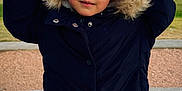 Sofia joined the competition — help win amazing prizes! child, coat, hood, fur, winter_clothing, outdoor, park, grass, sidewalk, curious, face, person, cold_weather, jacket, blue_pants, young, cute, portrait, daylight, nature