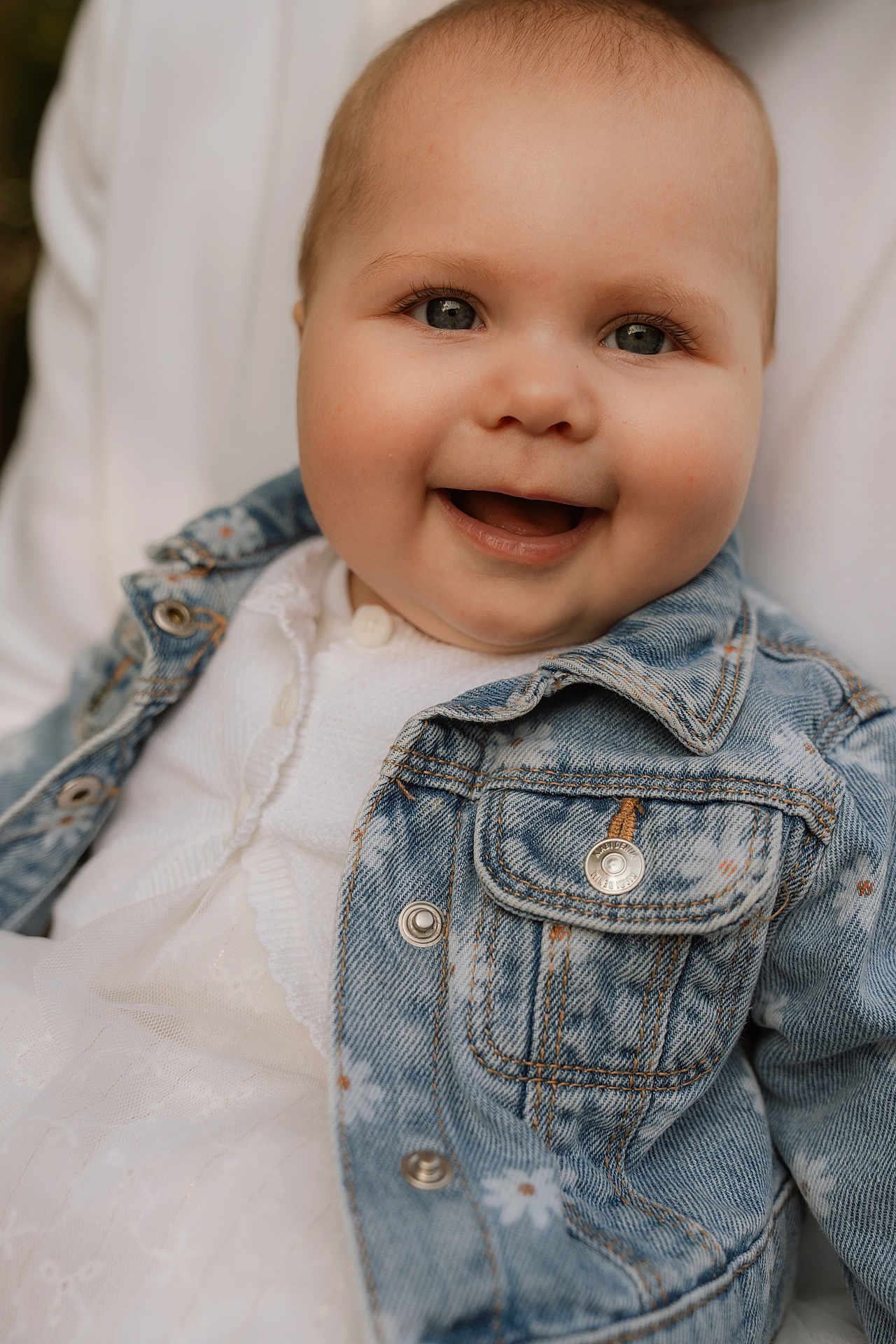 Léandra participe au concours pour gagner de l'argent avec cette photo : baby, child, smile, denim_jacket, white_dress, face, portrait, happy, cute, infant, clothing, button, texture, person, closeup, skin, eyes, mouth, cheeks, fashion