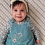 baby, child, smiling, headband, overalls, floral_pattern, knitted_blanket, cute, portrait, infant, happy, lying_down, blue_eyes, long_sleeves, embroidered_clothing, fairy_design, button, fabric_texture, person, indoors
