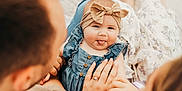 Emma is registered to the contest to win money with this photo: baby, child, adult, family, holding_hands, headband, denim_dress, tongue_out, playful, parent, mother, father, close_up, soft_light, outdoor, happy, candid, skin, portrait, togetherness