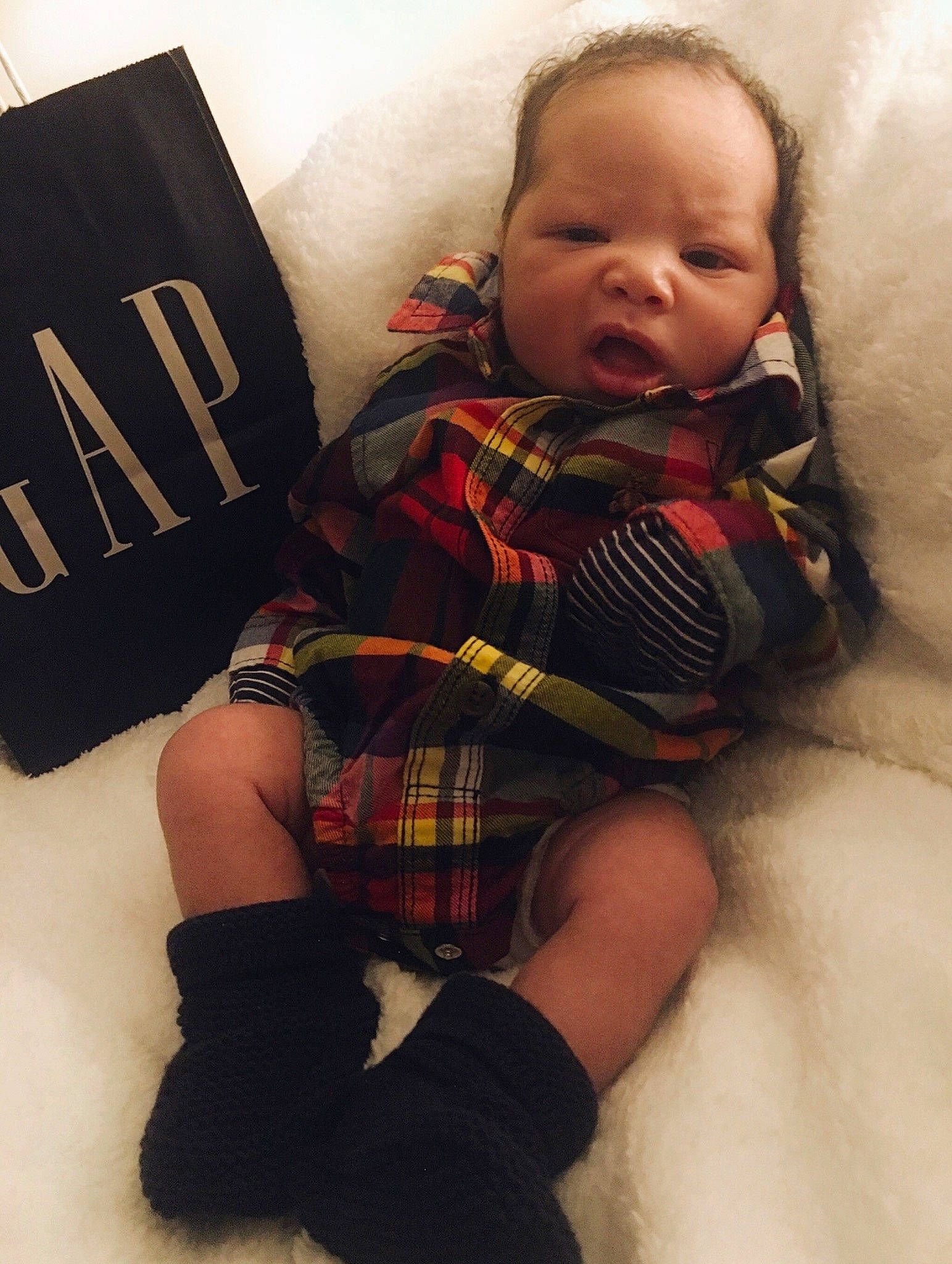 Carmelo is registered to the contest to win money with this photo: arm, baby, baby_toddler_clothing, cheek, comfort, cool, eye, face, finger, hair, head, joint, knee, person, product, skin, sleeve, tartan, textile, thigh