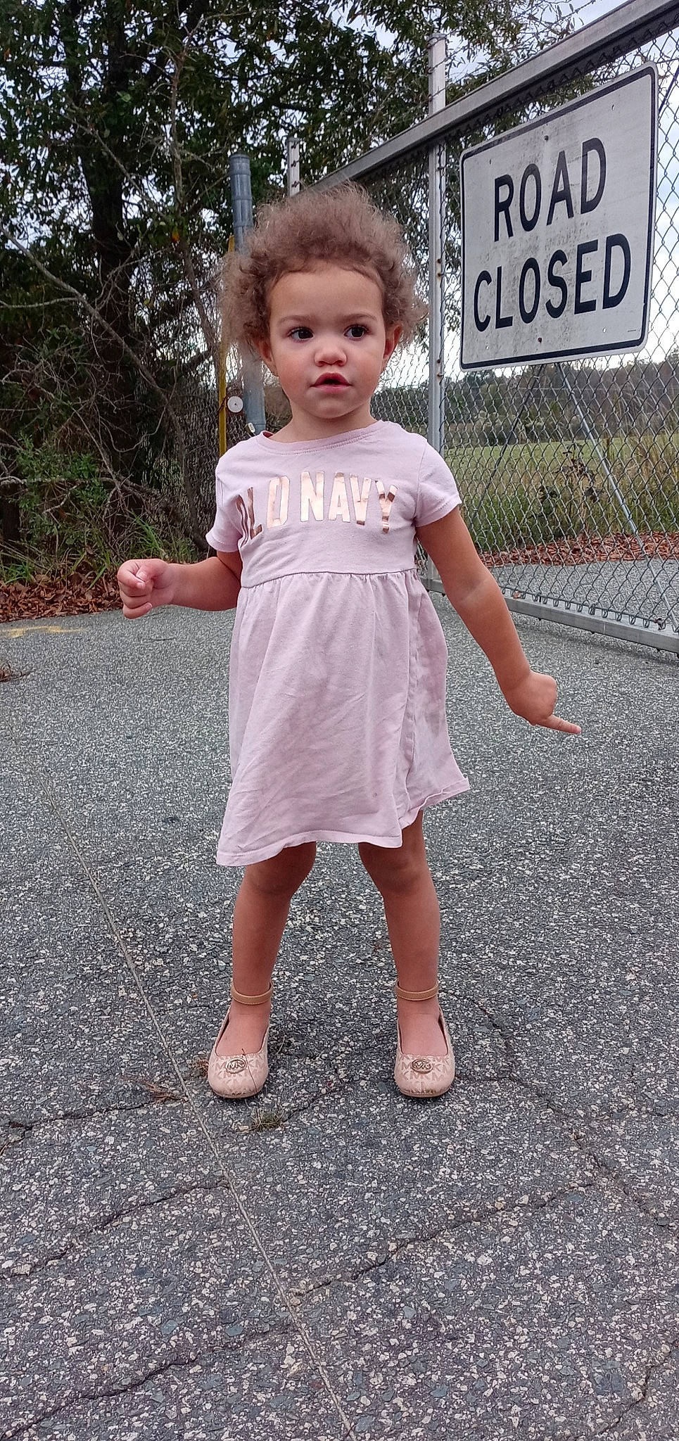 Alaia joined the competition — help win amazing prizes! asphalt, baby_toddler_clothing, child, day_dress, fence, gesture, grass, happy, head, human_leg, one_piece_garment, pattern, person, pink, plant, recreation, sandal, sleeve, toddler, tree