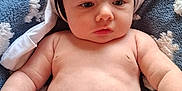 Elvis joined the competition — help win amazing prizes! baby, infant, diaper, blanket, soft_texture, skin, headwear, chubby, laying_down, indoors, child, cute, expression, closeup, human, person, small_hands, baby_skin, white_cloth, napkin