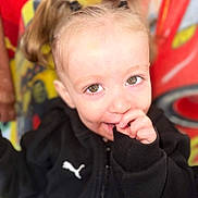 Chelsea participe au concours pour gagner de l'argent avec cette photo : apparel, baby, black_jacket, blond_hair, child, closeup, clothing, cute, eyes, face, happy, indoor, person, playful, portrait, puma_logo, smile, thumb, toddler, young_child