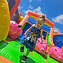 Chelsea participe au concours pour gagner de l'argent avec cette photo : activity, blue, bright, child, clouds, colorful, daytime, dress, fun, grass, happy, inflatable, outdoor, pink_pig, playground, shoes, sky, summer, toddler, toy