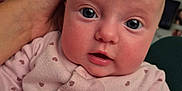 Ava-Melody is registered to the contest to win money with this photo: baby, infant, face, hand, pink_clothing, heart_pattern, close_up, skin, eyes, mouth, person, indoor, natural_light, soft_light, human, cute, young, child, portrait, expression