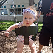 Abigail joined the competition — help win amazing prizes! baby, child, swing, playground, outdoor, headband, smile, adult, grass, tree, sunlight, building, person, happy, legs, clothing, summer, fun, park, woodchips