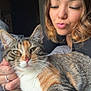 Cocoa is registered to the contest to win money with this photo: cat, tabby_cat, person, woman, face, pet, indoor, close_up, curly_hair, bed, blanket, resting, cute, affection, feline, paw, whiskers, relaxed, domestic_animal, companion