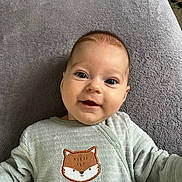 Léonie a rejoint le concours — aidez-le/la à gagner de superbes lots ! baby, infant, smiling, face, eyes, clothing, fox_design, embroidery, blanket, soft_texture, lying_down, cute, child, portrait, happy, indoors, young, person, toddler, apparel