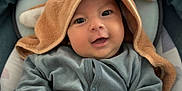 Zoé participe au concours pour gagner de l'argent avec cette photo : baby, infant, smiling, hood, blanket, cushion, blue_clothing, face, hand, cute, cozy, seat, child, soft_texture, indoor, portrait, happy, young_child, closeup, warm