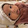 baby, close_up, face, hat, knit, brown_fleece, tongue_out, curious_eyes, infant, blanket, soft_texture, cute, indoors, warm_clothing, newborn, person, child, portrait, lying_down, cozy