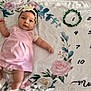 Zoé a rejoint le concours — aidez-le/la à gagner de superbes lots ! baby, infant, pink_dress, headband, flower, blanket, floral_pattern, milestone_tracker, months, green_wreath, cute, lying_down, soft_texture, child, portrait, indoors, small_feet, white_socks, curious_expression, adorable