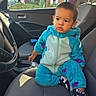 child, toddler, baby, car, car_interior, front_seat, passenger, portrait, sitting, fashion, tracksuit, turquoise, sneakers, clothing, face, short_hair, serious_expression, outdoor_background, vehicle, photography
