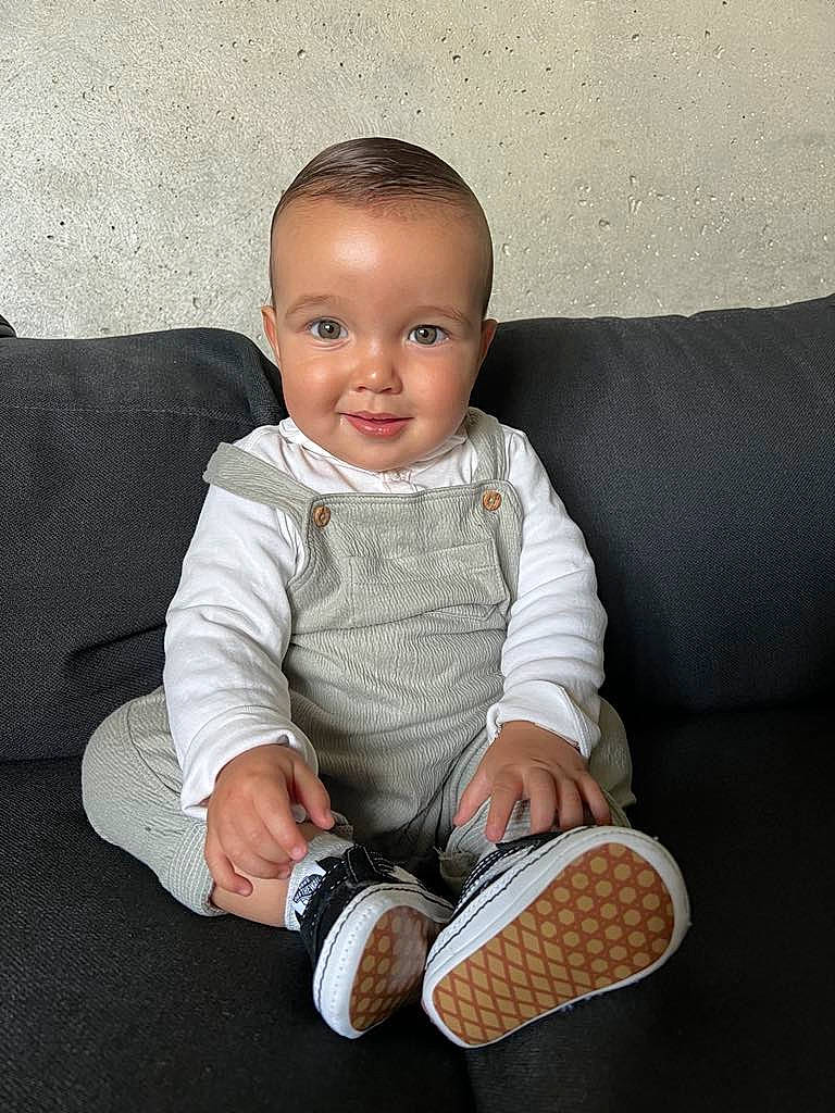 Naël participe au concours pour gagner de l'argent avec cette photo : arm, baby, baby_toddler_clothing, carmine, cheek, child, comfort, couch, foot, happy, human_leg, joy, pattern, person, product, sitting, sleeve, smile, sock, textile