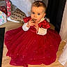 blue_eyes, child, curious, curtain, cute, decor, earrings, floor, gift_wrap, hair_tie, holiday, home, indoor, long_sleeve, person, pinecone, red_dress, sitting, toddler, wooden_floor