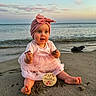 Lyla participe au concours pour gagner de l'argent avec cette photo : 11_months, baby, barefoot, beach, child, clouds, cute, happy, headwrap, infant, milestone_sign, ocean, outdoor, pink_dress, portrait, sand, sitting, sky, sunset, water