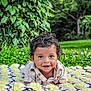 baby, blanket, child, crochet, cute, daylight, eyes, face, grass, greenery, hands, happy, infant, nature, outdoor, person, portrait, shirt, smile, young