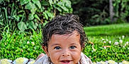 Maverick is registered to the contest to win money with this photo: baby, blanket, child, crochet, cute, daylight, eyes, face, grass, greenery, hands, happy, infant, nature, outdoor, person, portrait, shirt, smile, young
