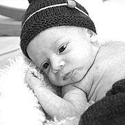 Nino a rejoint le concours — aidez-le/la à gagner de superbes lots ! baby, newborn, infant, hat, knitted_hat, pom_pom, blanket, soft_texture, black_and_white, portrait, close_up, sleepy, cute, cozy, resting, child, face, skin, hand, peaceful