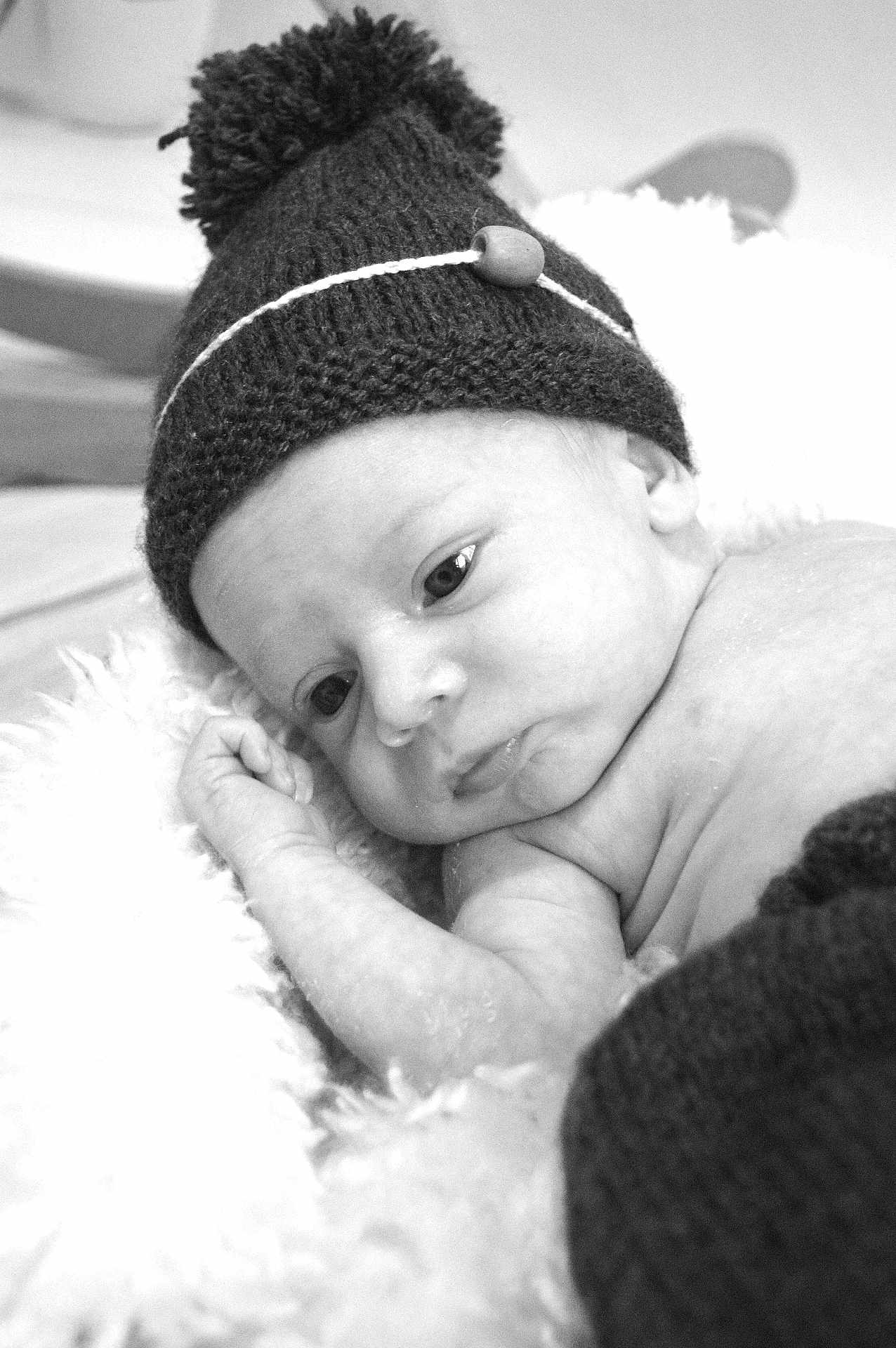 Nino a rejoint le concours — aidez-le/la à gagner de superbes lots ! baby, newborn, infant, hat, knitted_hat, pom_pom, blanket, soft_texture, black_and_white, portrait, close_up, sleepy, cute, cozy, resting, child, face, skin, hand, peaceful