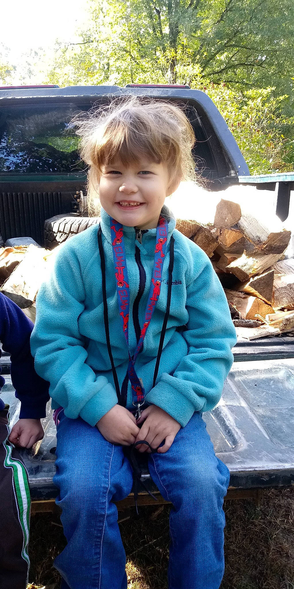 Bailey is registered to the contest to win money with this photo: automotive_exterior, bumper, chair, child, electric_blue, fun, grass, happy, joy, leisure, motor_vehicle, person, plant, recreation, sitting, smile, soil, toddler, tree, vacation