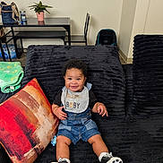 Royalty joined the competition — help win amazing prizes! baby, child, smiling, sitting, bib, couch, pillow, blanket, plant, table, chair, indoor, footwear, clothing, home, happy, person, portrait, black, decor