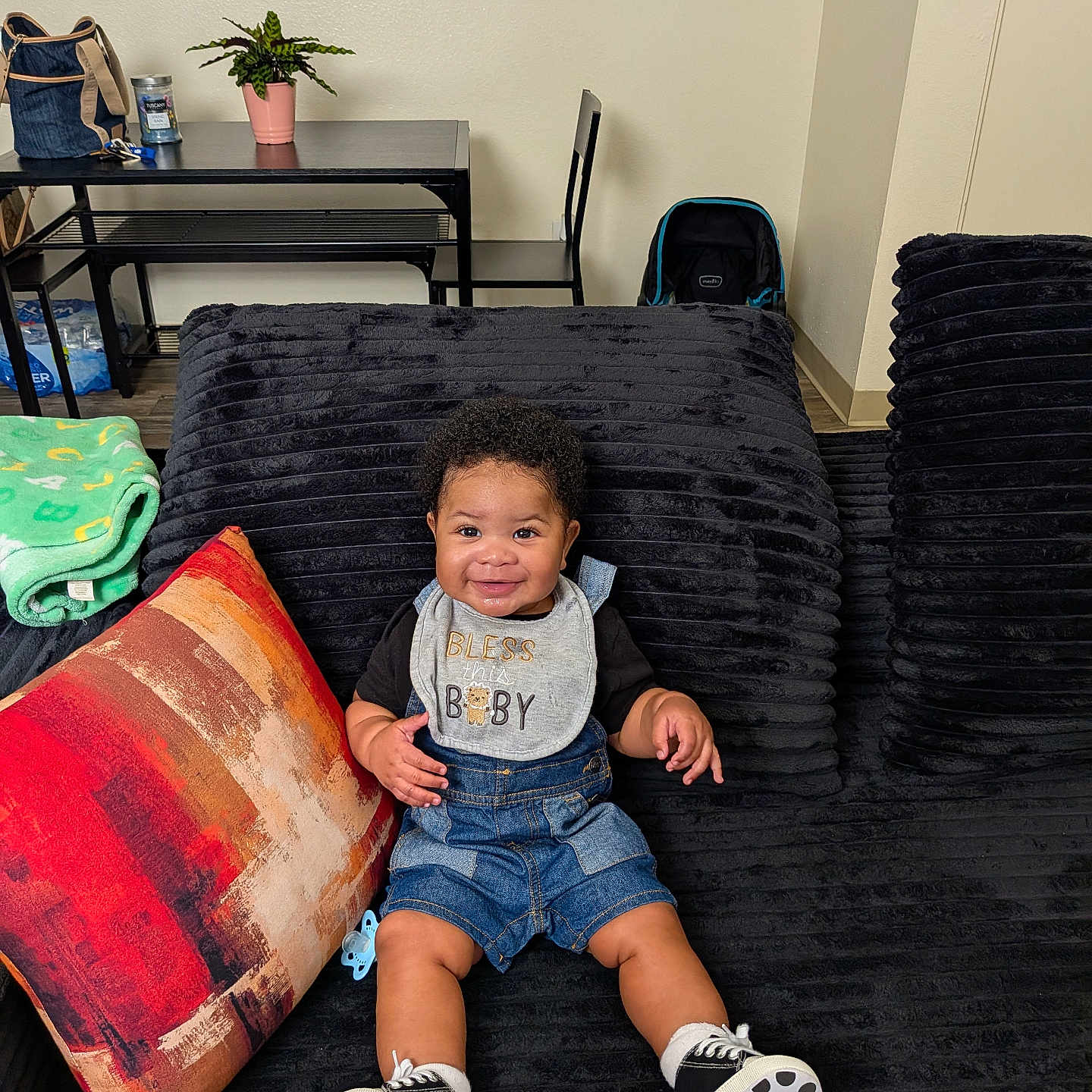 Royalty joined the competition — help win amazing prizes! baby, child, smiling, sitting, bib, couch, pillow, blanket, plant, table, chair, indoor, footwear, clothing, home, happy, person, portrait, black, decor