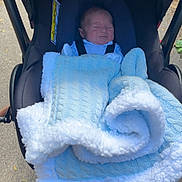 Damien is registered to the contest to win money with this photo: baby, blanket, blue, carriage, child, cozy, cute, daylight, face, infant, outdoor, person, pram, sleeping, stroller, transport, walkway, young, young_child, wrapped