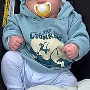 Damien joined the competition — help win amazing prizes! baby, blanket, car_seat, child, clothing, comfort, cute, expression, face, hands, hoodie, indoors, infant, lion_king, pacifier, portrait, seat, star_pattern, white_pants, young_child