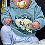 baby, blanket, car_seat, child, clothing, comfort, cute, expression, face, hands, hoodie, indoors, infant, lion_king, pacifier, portrait, seat, star_pattern, white_pants, young_child