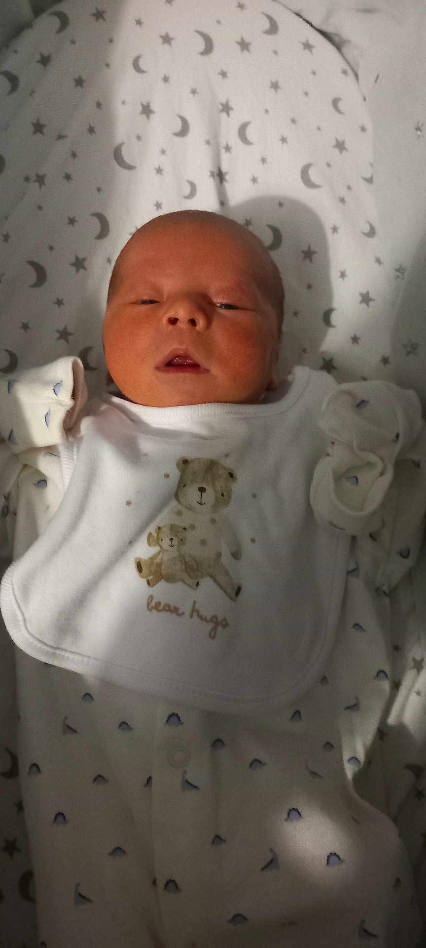 Abel is registered to the contest to win money with this photo: newborn, baby, infant, sleepy, bib, bear, blanket, stars, moon, pattern, white_clothing, cute, cozy, portrait, child, soft_light, indoor, face, small_hands, peaceful