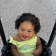 Aria joined the competition — help win amazing prizes! baby, child, swing, smiling, curly_hair, yellow_clothing, outdoor, playground, happy, infant, person, cute, portrait, seat, joyful, young_child, embroidery, flower, black_swing, texture