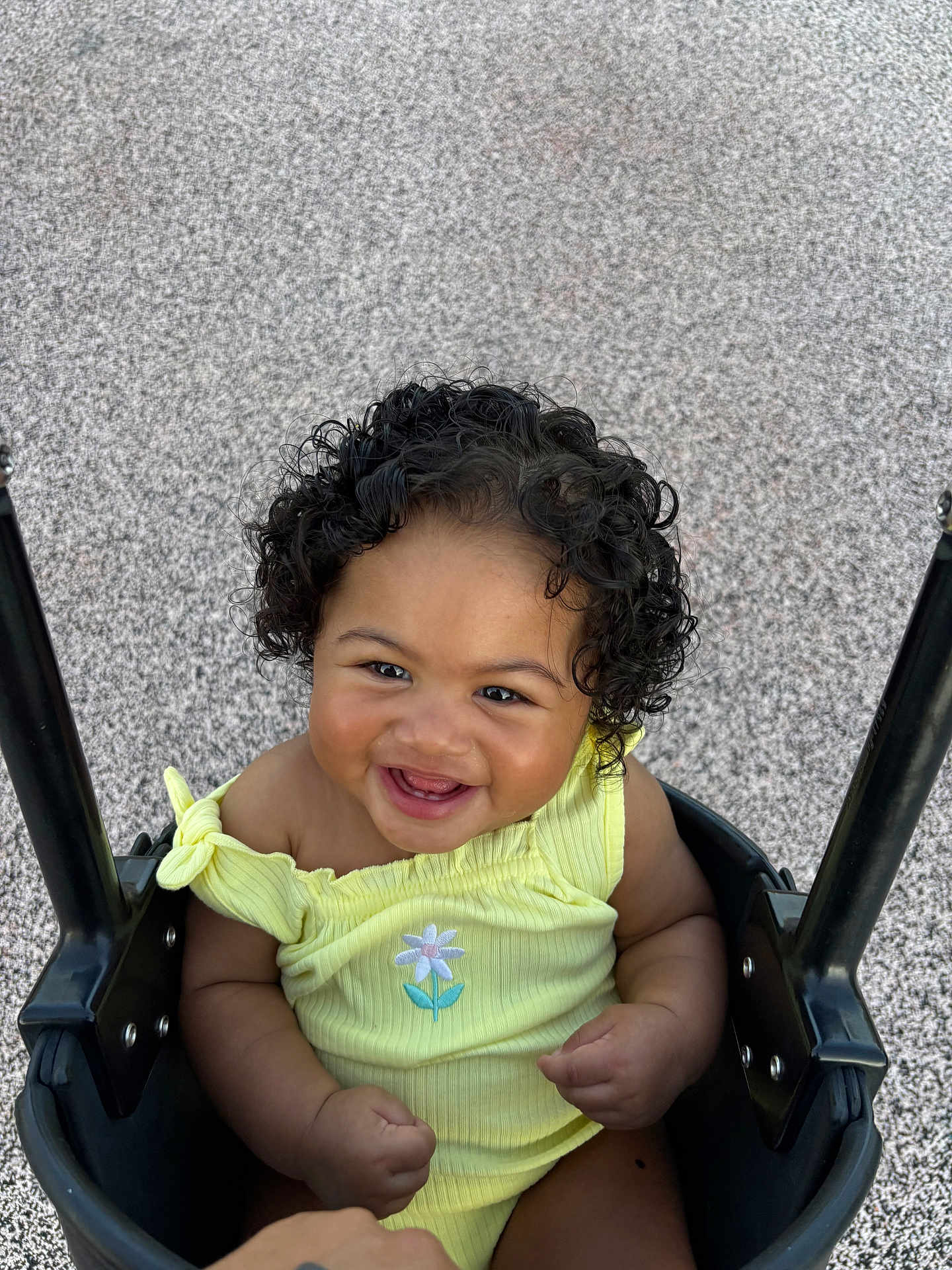 Aria joined the competition — help win amazing prizes! baby, child, swing, smiling, curly_hair, yellow_clothing, outdoor, playground, happy, infant, person, cute, portrait, seat, joyful, young_child, embroidery, flower, black_swing, texture