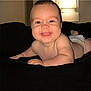 baby, smiling, diaper, indoor, lamp, black_background, happy, child, face, skin, infant, cute, cheeks, arm, photography, portrait, lying_down, light, room, expression