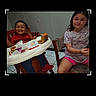 children, child, toddler, girl, boy, smiling, portrait, indoor, restaurant, fast_food, high_chair, table, meal, food, french_fries, drink, seated, family, phone_screenshot, photo_editing