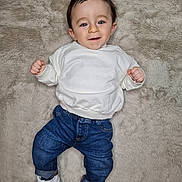 Isaac participe au concours pour gagner de l'argent avec cette photo : baby, blue_eyes, casual_clothing, child, cozy, cute, dark_hair, denim_jeans, feet, fur_rug, hands, happy, indoor, infant, lying_on_back, portrait, smile, sneakers, soft_texture, white_sweatshirt