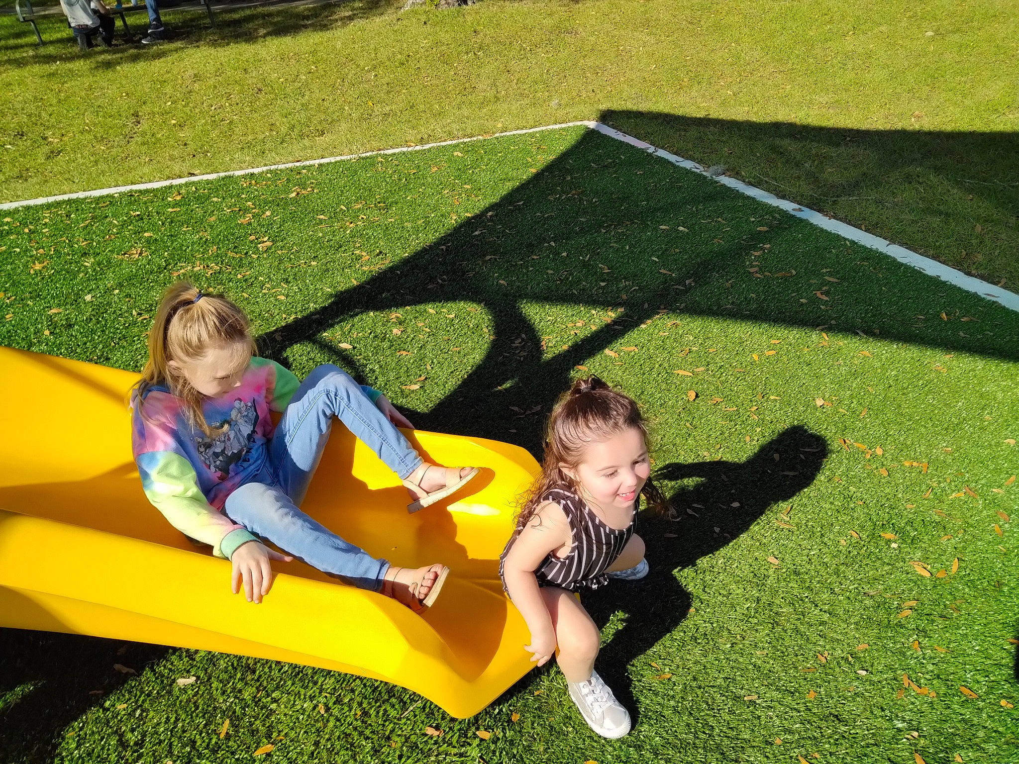 Jenna is registered to the contest to win money with this photo: flooring, fun, games, garden, grass, grass_family, grassland, happy, joy, lawn, leaf, leisure, outdoor_furniture, people_in_nature, person, plant, recreation, shade, shorts, sitting