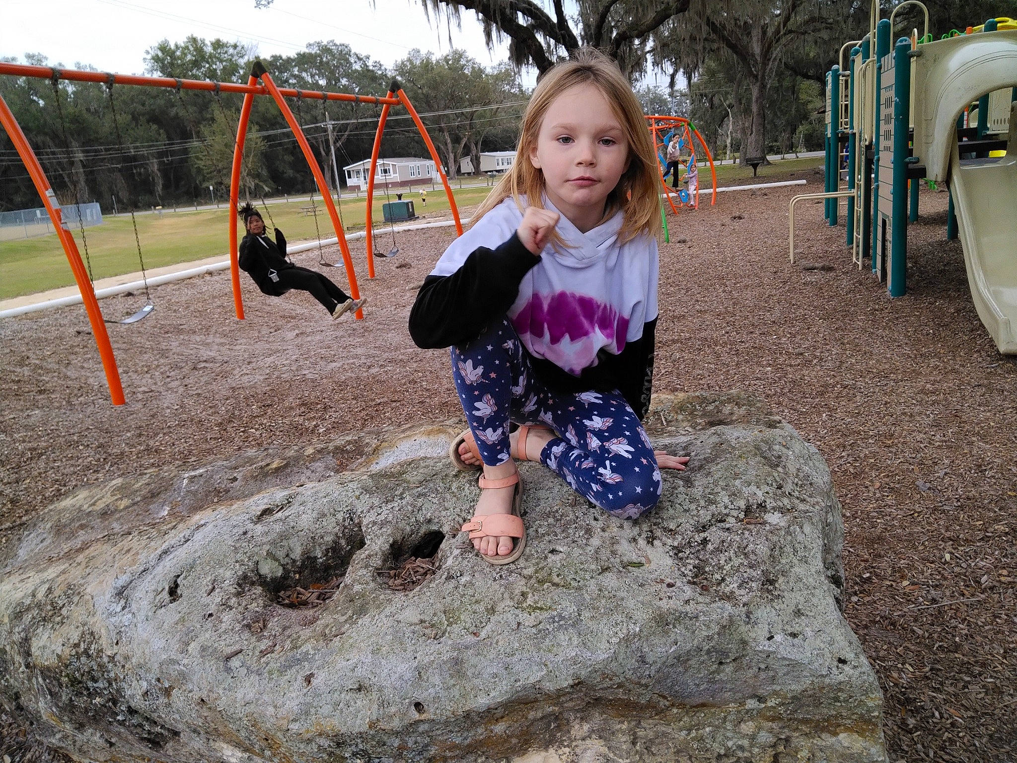 Braylee is registered to the contest to win money with this photo: child, city, fun, grass, happy, leisure, outdoor_play_equipment, people_in_nature, person, play, playground, playground_slide, recreation, sitting, sky, soil, swing, t_shirt, toddler, tree