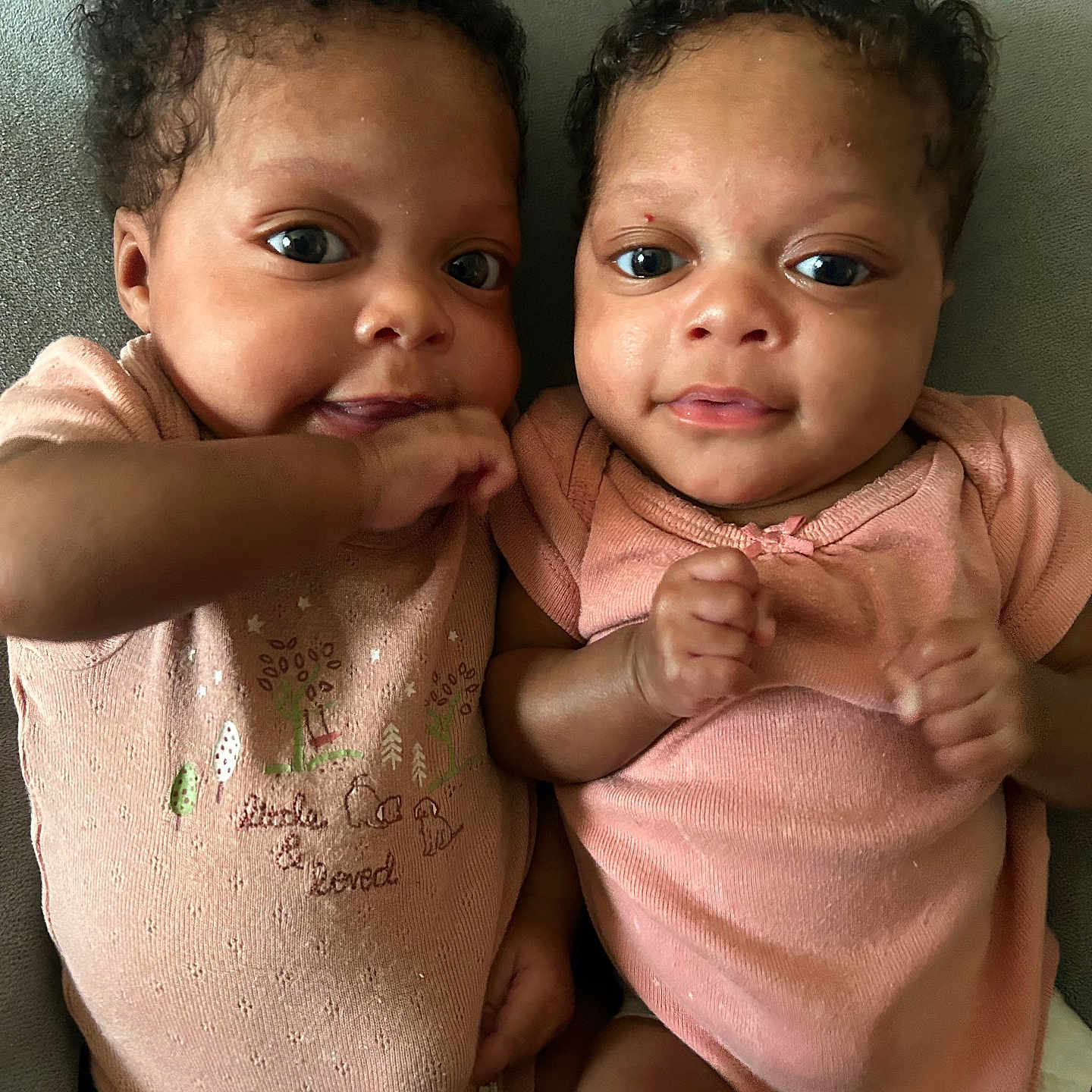 Hope And Faith is registered to the contest to win money with this photo: baby, infant, child, two_people, face, eyes, curly_hair, pink_clothing, lying_down, cute, adorable, skin, portrait, expression, hand, sibling, together, indoor, person, smile