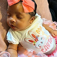 Ryleigh is registered to the contest to win money with this photo: accessories, baby, bodypart, clothing, couch, cushion, face, finger, furniture, hand, head, headband, homedecor, jewelry, newborn, person, photography, portrait, sitting, t_shirt