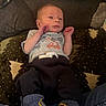 baby, infant, blanket, clothing, socks, face, person, indoor, baby_wipes, couch, pattern, toddler, cute, resting, newborn, soft_lighting, casual, comfort, small_hands, young_child