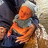 Derrick is registered to the contest to win money with this photo: baby, newborn, infant, blue_clothing, hat, hands, blanket, soft_texture, indoor, person, human, cute, sleepy, resting, warm_lighting, comfort, care, family, toddler, portrait