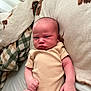 Roman joined the competition — help win amazing prizes! baby, infant, onesie, bed, blanket, pattern, plaid, face, skin, expression, fist, lying_down, indoors, cute, newborn, person, human, soft, comfort, rest