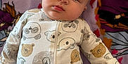 Braxlee is registered to the contest to win money with this photo: baby, infant, onesie, animal_print, blanket, lying_down, face, child, cute, soft_texture, indoors, portrait, sleepwear, cozy, hand, skin, expression, young, head, comfort
