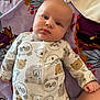 baby, infant, onesie, animal_print, blanket, lying_down, face, child, cute, soft_texture, indoors, portrait, sleepwear, cozy, hand, skin, expression, young, head, comfort